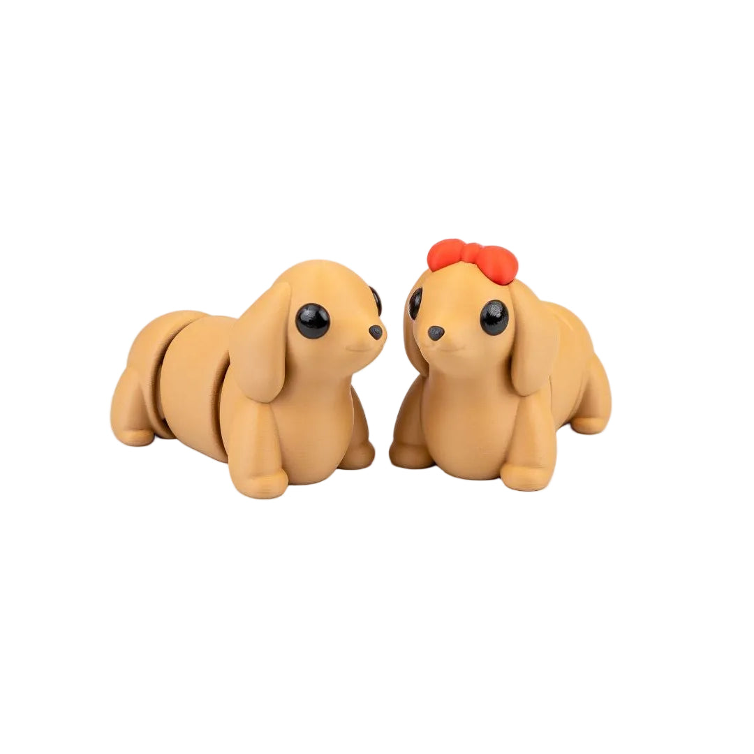 Two small dog figurines on a white surface with flowers in the background