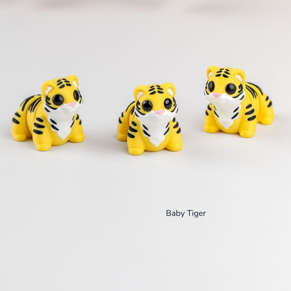Three small tiger figurines on a white background